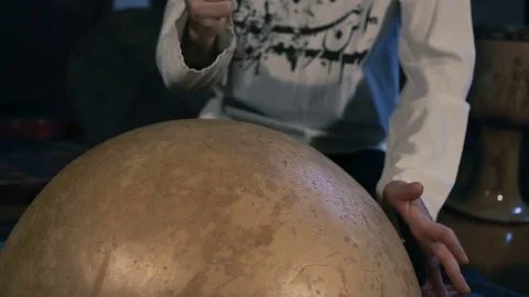 Man drumming out a beat on an arabic percussion drum named Calabasse at home. Stock Footage 74519689