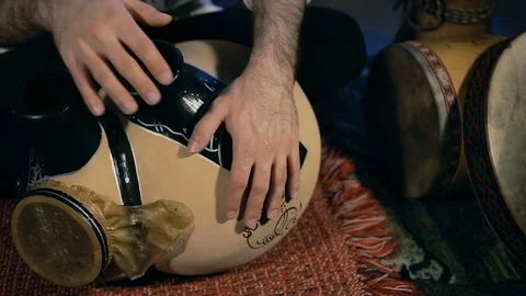 Man drumming out a beat on an arabic percussion drum named Frudu Vidéo 74520196
