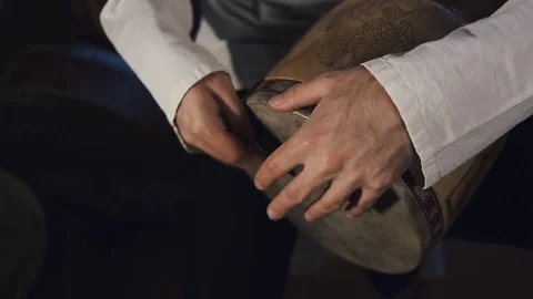 Man drumming out a beat on an arabic percussion drum named Tombak at home. Stock Footage 74525196