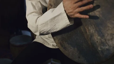 Man drumming out a beat on an arabic percussion drum named Bendir at home. Stockbeeldmateriaal 74525217