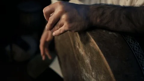 Man drumming out a beat on an arabic percussion drum named Bendir at home. Stockbeeldmateriaal 74525348