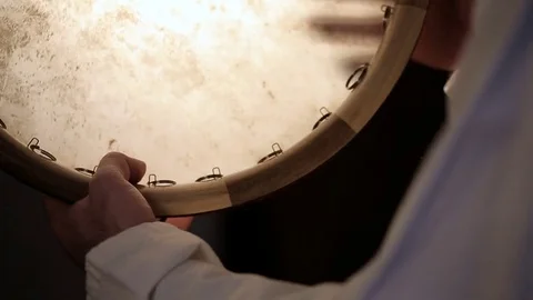 Man drumming out a beat on an arabic percussion drum named Dayereh at home. Video stock 74525762