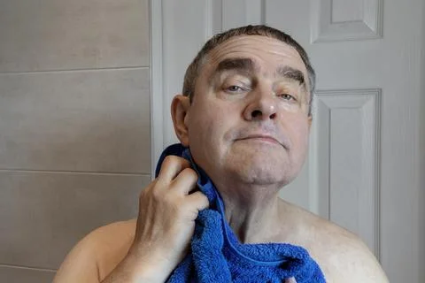 Man Drying Face with Blue Towel After Shaving Facial Hair Foto stock