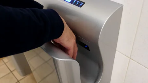Man drying hands using dryer in the restroom 库存影片 199041336