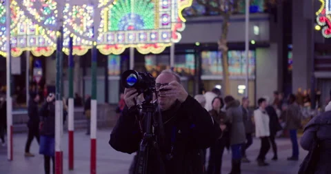 Man with DSLR camera and tripod Making a photo Stock Footage 56835779
