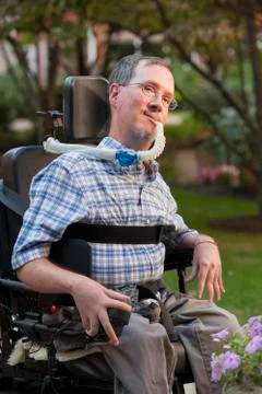 Man with Duchenne muscular dystrophy sitting in a wheelchair with a breathing Stock Photos