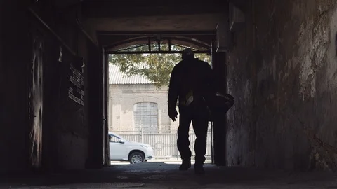 Man with duffel bag walks through dark tunnel in slow motion red helium 8K Video stock 122532683