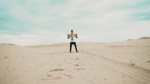 Man with dumbbells in desert Vídeo Stock 90486691