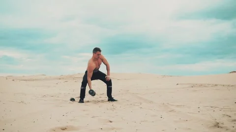 Man with dumbbells in desert Stock Footage 90486912
