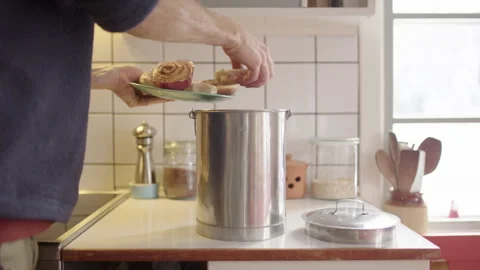 Man dumps stale donuts on plate into steel composting bin in kitchen Stock Footage 297187678