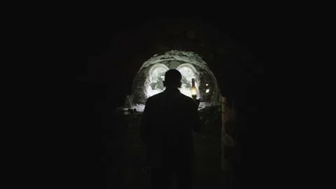 A man in a dungeon with a gas lamp. Exploring the catacombs with a torch Stock Footage 236335847