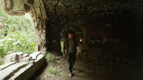 A man in a dungeon, walking to an unknown place with a gas lamp Stock Footage 235175141