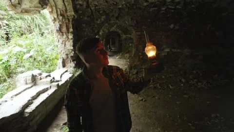 A man in a dungeon, walking to an unknown place with a gas lamp Stock Footage 235175222