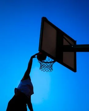 Man dunking over blue sky Stock Photos