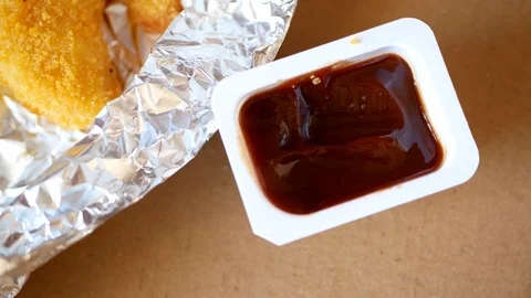 Man dunks a piece of chicken strip in the sauce. Stock Footage 70403980