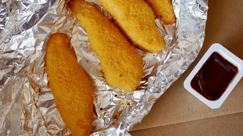 Man dunks a piece of chicken strip in the sauce. Stock Footage 70410778