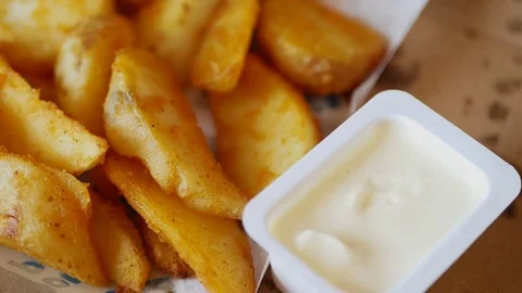 Man dunks a piece of fried potatoes in the sauce. Stock Footage 70402710