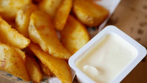 Man dunks a piece of fried potatoes in the sauce. Stock Footage 70402944