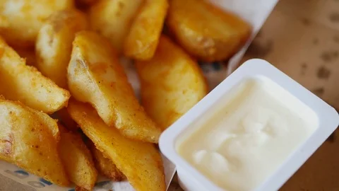 Man dunks a piece of fried potatoes in the sauce. Stock Footage 70403026