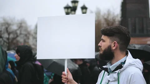 Man during rain with empty mockup advertisement poster panel for advert logo. Video stock 164885468