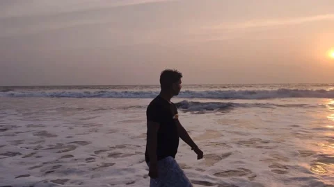 Man during sunset walk at the beach Stock Footage 146013162