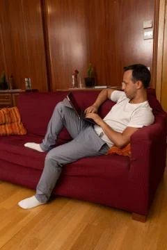 Man during vacations using tablet at home alone Stock Photos