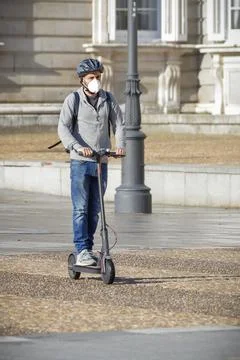 Man on e-scooter with mask . Stock Photos