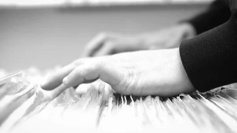 A Man eagerly browses through a selection of vintage records B&amp;W Stock Footage 74849999
