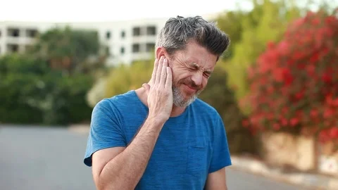 Man with earache is holding his aching ear body pain concept Stock Footage 120175438