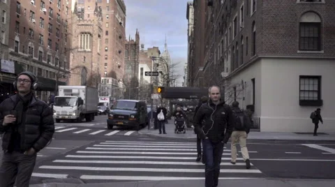 Man with earbuds walking on Lower 5th Ave Empire State Building Manhattan NYC Stock Footage 59270839