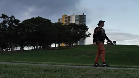 Man with earing walking through Sydney Park slow motion 4K Video stock 241760445