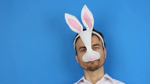 Man in easter bunny mask and protect gloves smile and puts on medical mask Stock-Footage 126998897