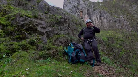 Man eating an apple after climbing on a rock - via ferrata/klettersteig 스톡 동영상 220737452
