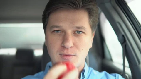 A man is eating an apple in a car. Stock Footage 81828119