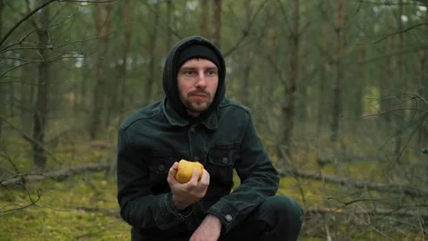 Man eating an apple in the forest Stock Footage 191840975