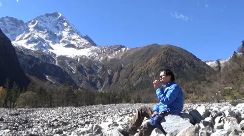 Man eating apple when trekking in the snow mountain area Stock Footage 43503584