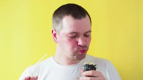 Man eating asian food on yellow background Stock Footage 171301853