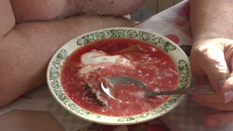Man eating beetroot soup for lunch Stock Footage 183413439