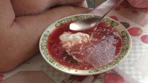 Man eating beetroot soup for lunch Stock Footage 183431425