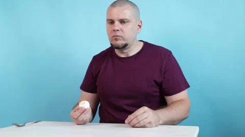 Man Eating boiled egg on Blue Background, breakfast and fresh boiled meal, .. Stock Footage 301286974