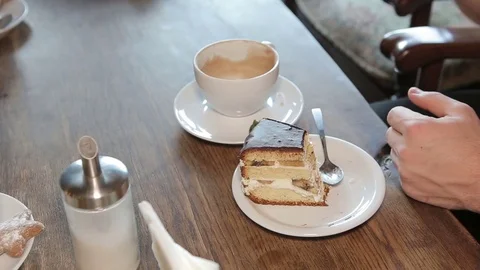 Man eating cake and drinking tea in a cafe in the city. Stock Footage 71347295