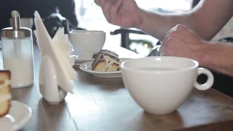 Man eating cake and drinking tea in a cafe in the city. Stock Footage 71347323