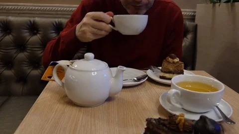 Man eating cake and drinking tea 스톡 동영상 73396867