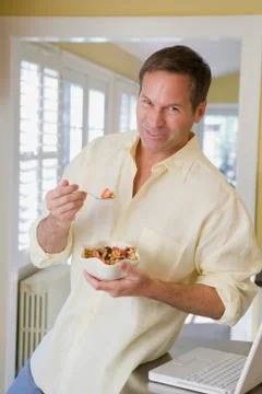 Man eating cereal in kitchen Stock Photos