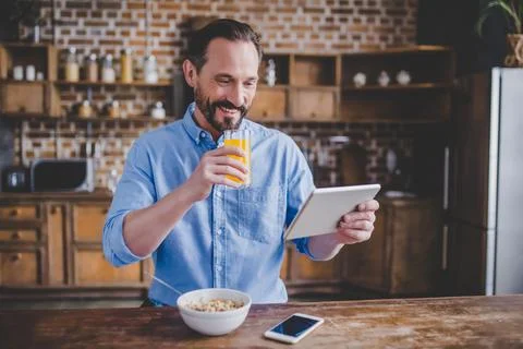 Man eating cereals and using digital tablet Stock Photos