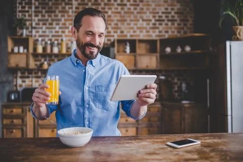 Man eating cereals and using digital tablet Stock Photos