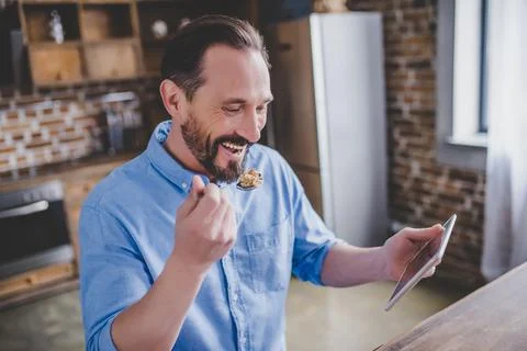 Man eating cereals and using digital tablet Stock Photos