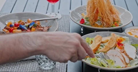 Man eating chicken Caesar salad at restaurant table Stock Footage 332774901