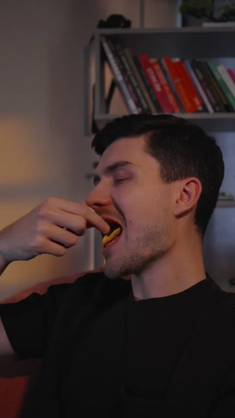 Man Eating Chips at Home Close Up Snack Moment Vertical Video Видео 332553625