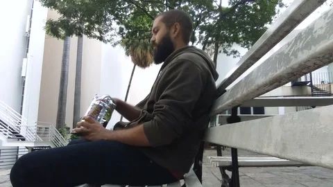 Man Eating Chips On Park Bench 스톡 동영상 71476236